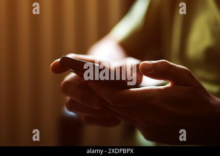 Close up of male hands using mobile phone indoors, selective focus Stock Photo