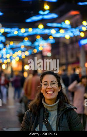 Young woman laughing at the camera at night in Eindhoven city center Stock Photo