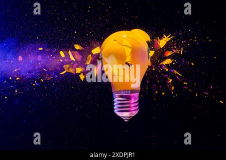 Yellow light bulb exploding black background real high speed image Stock Photo
