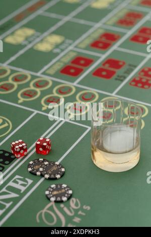 Dice, poker chips, and whiskey on casino table Stock Photo