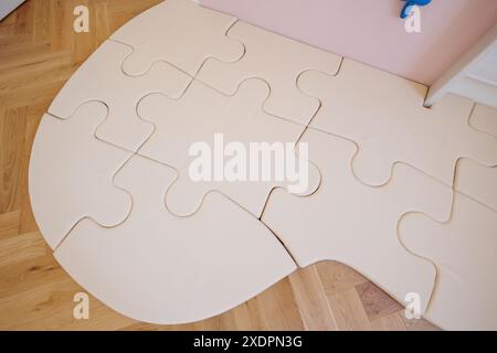 Light pink pastel playroom foam floor tiles. Soft floor. Baby mat puzzle carpet mat for children in room on wooden floor Stock Photo