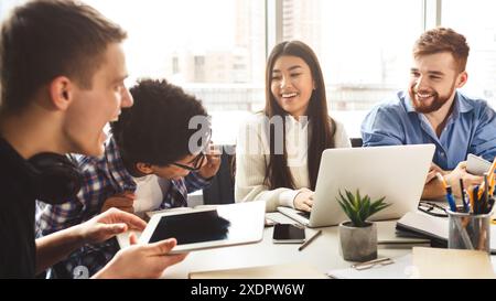 Students of diverse backgrounds using tech in study Stock Photo