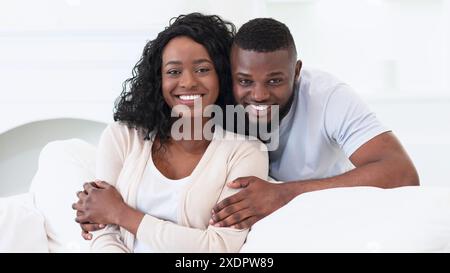 Happy Couple Posing Together on a Bed Stock Photo
