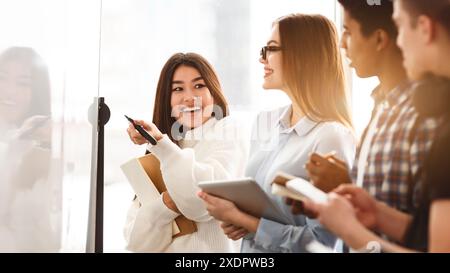Group of Zoomers Standing in Front of Whiteboard Stock Photo