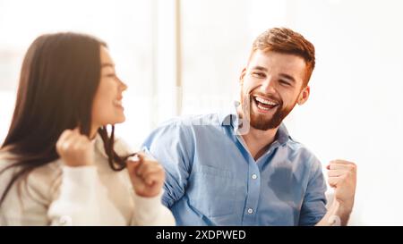 Young Man and Woman Laughing in Office Stock Photo