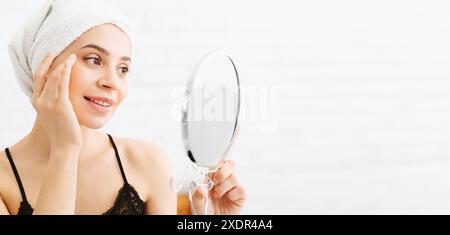 Woman Holding Mirror With Towel on Head Stock Photo