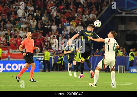 Stuttgart, Germany, 23rd Jun, 2024. Lawrence Shankland heads the ball whilst having his shirt pulled by Willy Orban during the match between Scotland and Hungary at the Stuttgart arena, at EURO 2024 Stuttgart, Germany. Photo credit: Paul Blake/Alamy Sports News Stock Photo