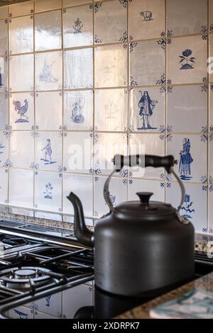 Kettle on hob with Delft tiles in 16th century Tudor farmhouse, Hertfordshire, England, UK Stock Photo