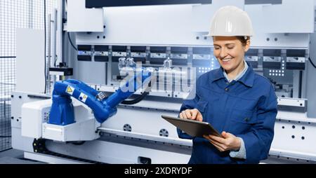 Engineer uses a digital tablet to control robots in a smart factory. Smart industry 4.0 concept.. Stock Photo