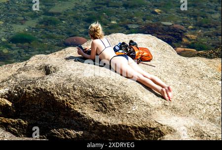 St Andrews, Fife, Scotland, UK. 24th June 2024. UK Weather: St Andrews in Fife, Scotland, has bright sunshine with temperatures reaching 23°C. The hot June weather draws both locals and tourists to Castle Beach where people enjoy the Scottish summer and sunbathe.  Credit: Dundee Photographics/Alamy Live News Stock Photo