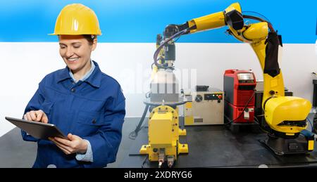 Engineer uses a digital tablet to control robots in a smart factory. Smart industry 4.0 concept. Stock Photo