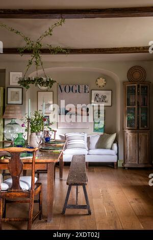 Chandelier with faux ivy and 1940s Vogue cover in dining room of charming Somerset rectory dating from 17th century, South West England, UK. Stock Photo