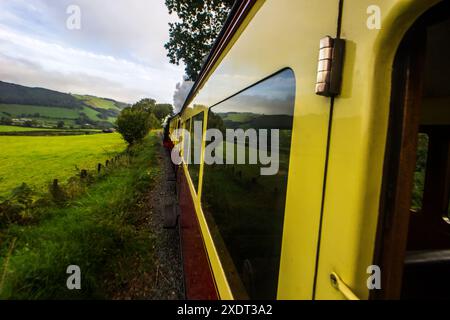 Reflections of the Welsh countryside on the carriages of the Vale of Rheidol Steam train as it travels through the Rheidol Valley Stock Photo