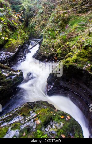 The fast flowing stream of the river Mynach flowing through a series of potholes known as the Devils Punch bowl in the Cambrian Mountains of Wales Stock Photo