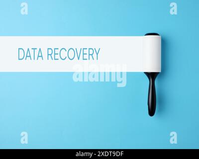 Data recovery, data loss, backup and restoration technology concept. Lint roller with white trace on blue background with the message data recovery. Stock Photo