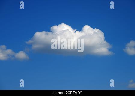 one single white cumulus cloud in the blue sky in summer Stock Photo