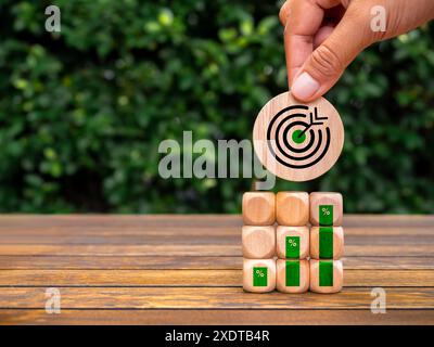 Green business, goal and growth success process for Leadership concept. Big target icon round block in hand put on cube stack with growth graph percen Stock Photo