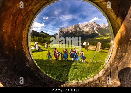 The view through a wooden peephole on the Sound of Music Trail near Werfen, Salzburg, Austria, creates the perfect illusion for fans of the film The Sound of Music. The view of the Tennengebirge mountains is just as real as the other visitors at the end of the trail. Only the dancing Trapp family children with Julie Andrews are stamped into the scenery as figures. Stock Photo
