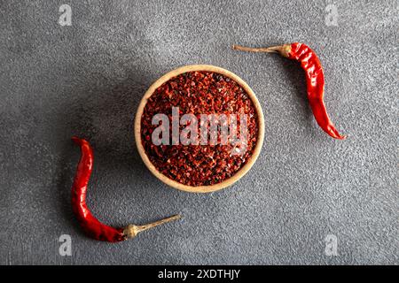 Red pepper flakes.Red chili peppers in wooden bowl on gray background.Dried chili peppers Stock Photo