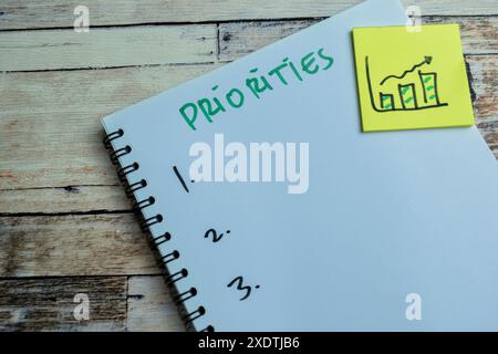 Concept of Priorities write on book isolated on Wooden Table. Stock Photo