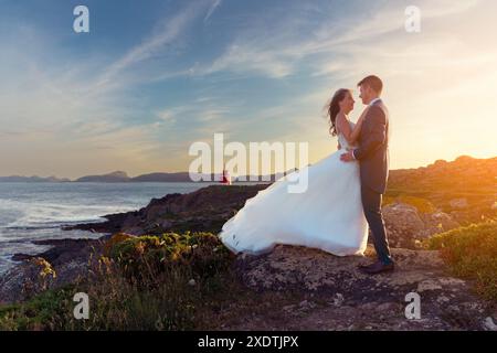 Bride and groom looking at each other near a lighthouse after the wedding Stock Photo