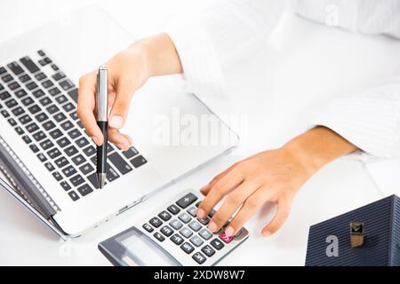 Real estate agent working with laptop at table in office.hand using laptop and calculator Stock Photo