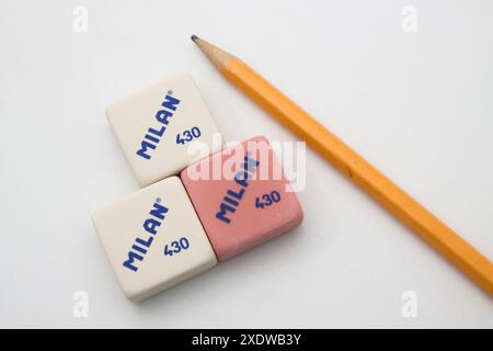 Three white and pink erasers from the Milan brand model 430 next to a pencil on a white background Stock Photo