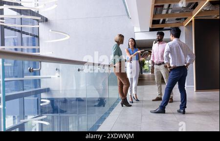 Group of business people discussing project in modern office hallway Stock Photo