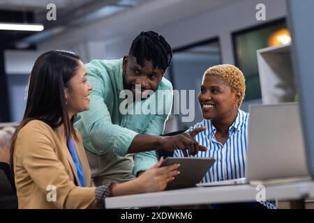 Group of business people collaborating on project with laptop and tablet in office Stock Photo