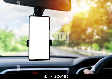 Smart phone with blank screen in car windshield holder. Empty screen for your advertise design. A blank white screen smartphone on a car dashboard wit Stock Photo