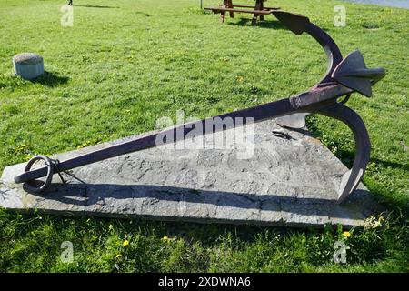 Old metal ship anchor displayed outside in public park Stock Photo