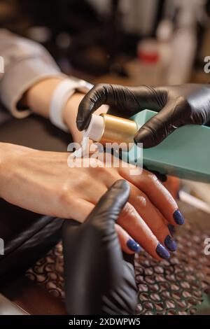 manicurist applies cream to client's hands for hand care in beauty salon, concept of skin problem on hands Stock Photo