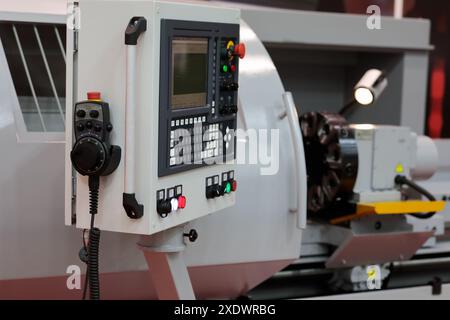 CNC lathe metalworking machining center with control panel and remote controller on the foreground. Selective focus. Stock Photo