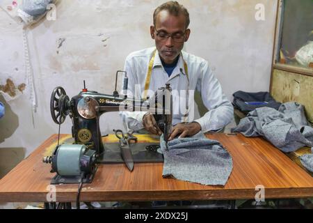 India, Uttar Pradesh, Varanasi, Bangali Tola. Man using sewing machine. Stock Photo