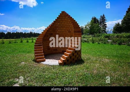 A spiral of bricks standing in a grassy field, creating a unique architectural form-preparation for roasting and grilling. Stock Photo