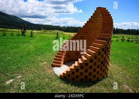 A spiral of bricks standing in a grassy field, creating a unique architectural form-preparation for roasting and grilling. Stock Photo