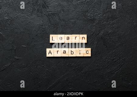learn arabic word written on wood block. learn arabic text on table, concept. Stock Photo