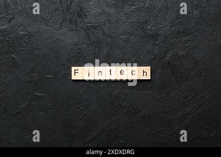 FINTECH word written on wood block. FINTECH text on cement table for your desing, concept. Stock Photo