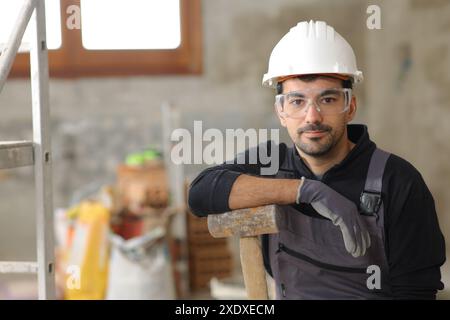 Front view portrait of a serious construction worker posing in a house under renovation Stock Photo