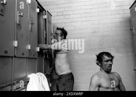Shift Work, coal mining Yorkshire coalfields England 1970s. At the end of the day at the coal face, Dave Bennett, an official and Ernie Moore a Face Man change out of their working clothes. There were two sides the clean and dirty side, a miner had a locker in each, and on the dirty side he hung his 'pit black' working clothes before going into the shower room and then into the clean locker room. South Kirkby, Yorkshire England 1979. 1970s UK HOMER SYKES Stock Photo