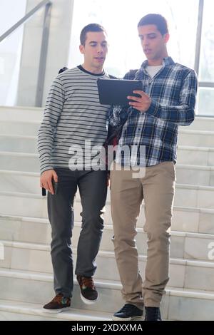 Young students at campus using digital tablet Stock Photo