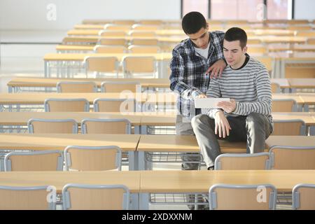 Young students at campus using digital tablet Stock Photo