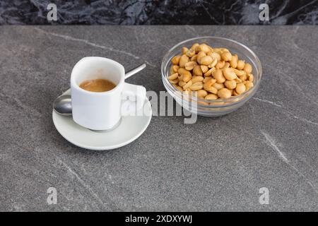 Cup of coffee and roasted nuts on a marble table. Stock Photo