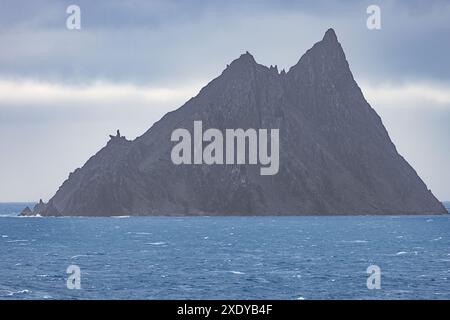 The dark rocks of Rowett Island near Cape Lookout just south of Elephant Island, a mountainous island off the coast of Antarctica Stock Photo