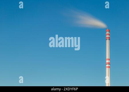 Smoke from a tall chimney in the clear sky Stock Photo