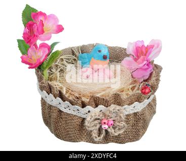 Easter handmade  nest   from canvas  and  flowers with  funny blue  clay bird and eggs  isolated Stock Photo