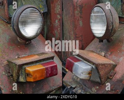 Broken spotlights  on the rusty iron vintage tractor Stock Photo