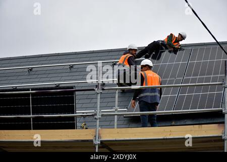 Workers installing solar panels on a roof in Ardara, County Donegal, Ireland. Stock Photo