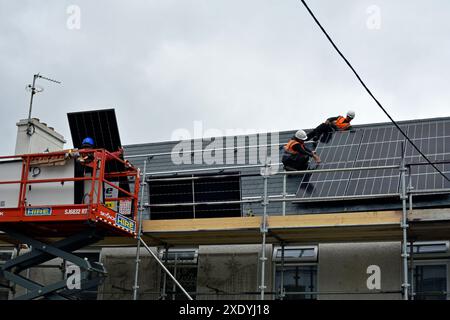 Workers installing solar panels on a roof in Ardara, County Donegal, Ireland. Stock Photo