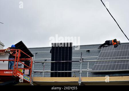 Workers installing solar panels on a roof in Ardara, County Donegal, Ireland. Stock Photo